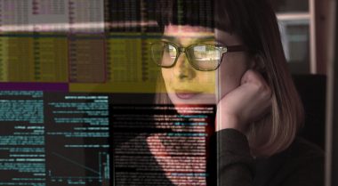 women wearing glasses looking at data on a computer screen